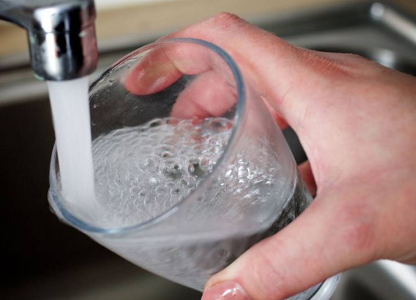 robinet ouvert déversent de l'eau dans un verre